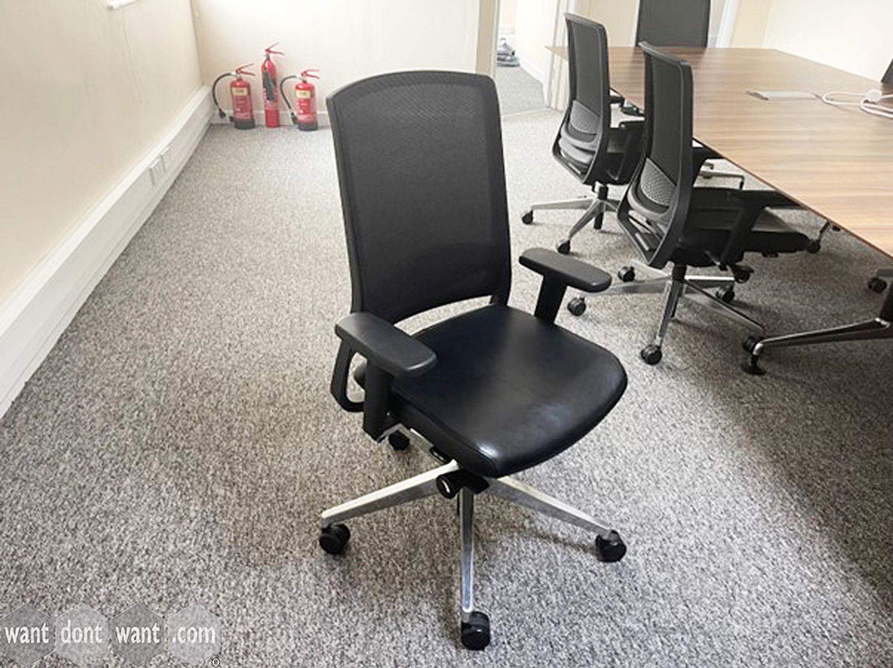 Used Gispen task chairs with black leather seats and mesh backs.