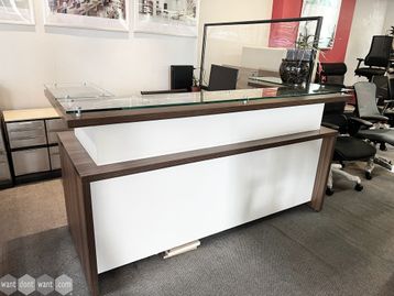 An excellent used modern office reception with glass counter tops and side return.