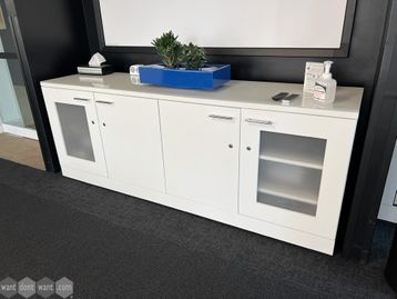Used white 4 door credenzas with opaque end doors and shelves.