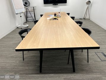 Used meeting table in light oak MFC with black legs and cable access door.