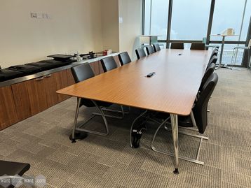 A Used walnut veneer boardroom/meeting table with inset power modules and chrome legs.