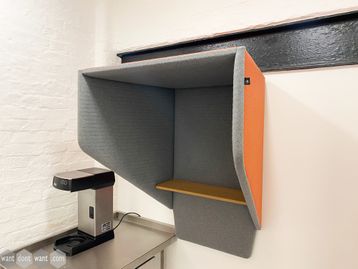 Used acoustic 'Buzzi Booth' units upholstered in grey and orange fabric.